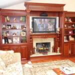 This Cherry wood wall unit features intricately carved moldings and corbels, an elaborate fireplace mantle and granite surrounding the fireplace.