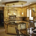 This old world styled kitchen is sprayed with our off-white lacquer and hand brushed in our antique umber glaze.  It features lighting, granite countertops, fluted columns, intricate hand carved corbels, along with a hand carved crown molding around the kitchen.