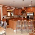 This Maple kitchen features raised panel doors, stainless steel appliances, granite countertops with ogee edges, and a matching granite kitchen table with seating for 10.