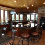 This Cherry kitchen finished in our Japanese Sienna stain features raised panel doors, stainless steel appliances, granite countertops, matching metal chairs, a large island with seating for 5.
