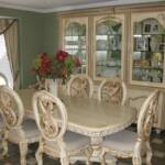 This old world styled dining room set is antiqued sprayed an off-white lacquer and hand brushed in our antique umber glaze.  The dining room table is hand carved and features seating for 10 with a removable leaf.  The breakfront features hand carved raised panel doors, glass doors, glass shelves...
